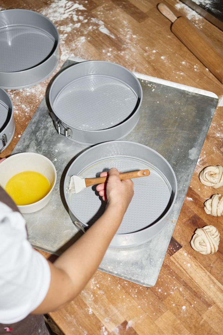 To prevent the cake from sticking to Nordwik's baking tin during the baking process, Lilian brushes it with butter using a brush.