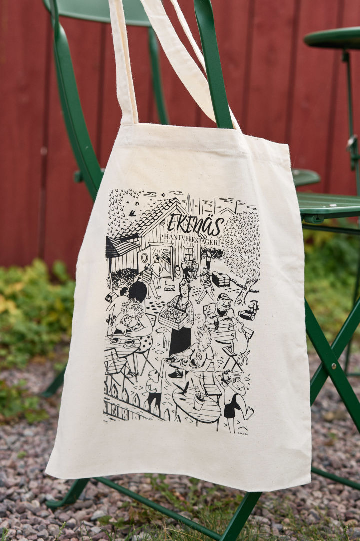 Lilian offers a pretty fabric bag for her Ekenäs Hantverksbageri, on which her bakery and the front garden area with guests have been artistically depicted.